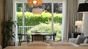 Una habitación con balcón, una mesa de comedor y un sofá.