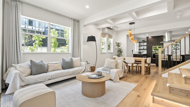 Una sala de estar moderna con sofá, mesa de centro y comedor.