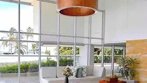 A modern interior with a pool, large windows, and a white sofa. - CRESPO OCEAN VIEW APT (Cartagena de Indias)