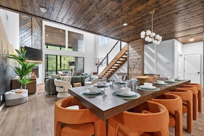 Ein modernes Interieur mit Essbereich, Holzboden und einer Treppe.