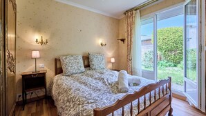 Un dormitorio con una cama grande, dos lámparas de noche, una mesita de noche y vistas a zonas verdes.