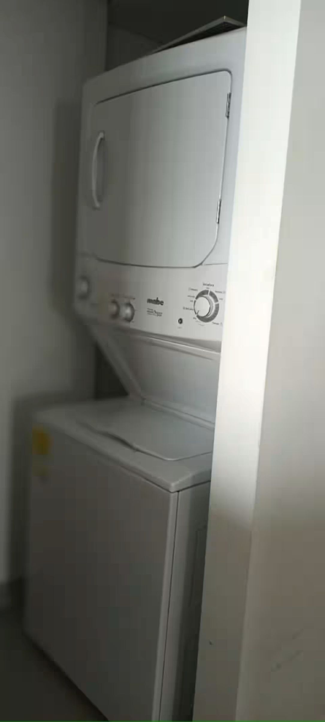 A front view of a washing machine and dryer unit in a laundry room.