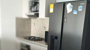 Een moderne keuken met een roestvrijstalen koelkast, een inbouwoven en een granieten aanrecht.