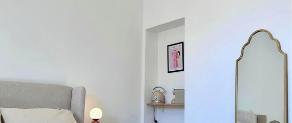 A bedroom with a bed, bedside table, lamp, framed picture, and a mirror. - Piazza Condo   Suite with Balcony (ACQUASPARTA)