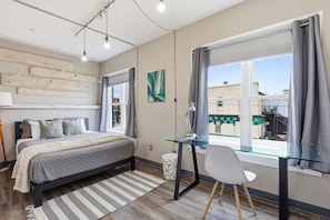 A modern bedroom with a bed, desk, and window. - Stateview 203 - 1BR + Free Co-Working Space (Appleton)