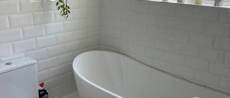 A bathroom with a toilet, bidet, bathtub, and sink.