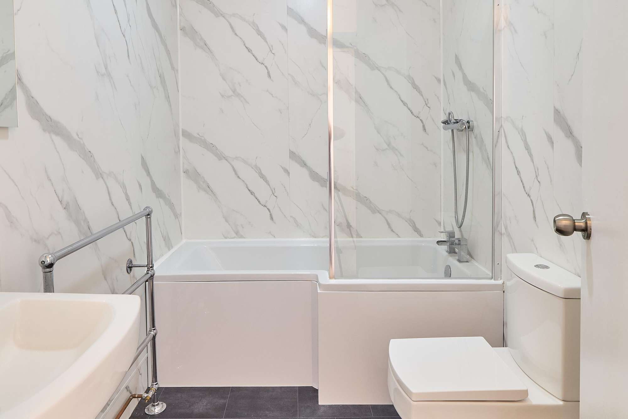 A bathroom with a glass-enclosed shower, a bathtub, and a toilet.