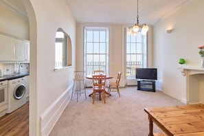 A compact living space with a kitchen, dining area, and a TV.