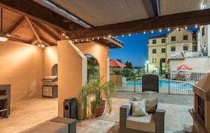 An outdoor patio area with a grill, seating, and a pool. - Accessible 1BR Suite w/ Kitchen | Free Breakfast! (Irving)