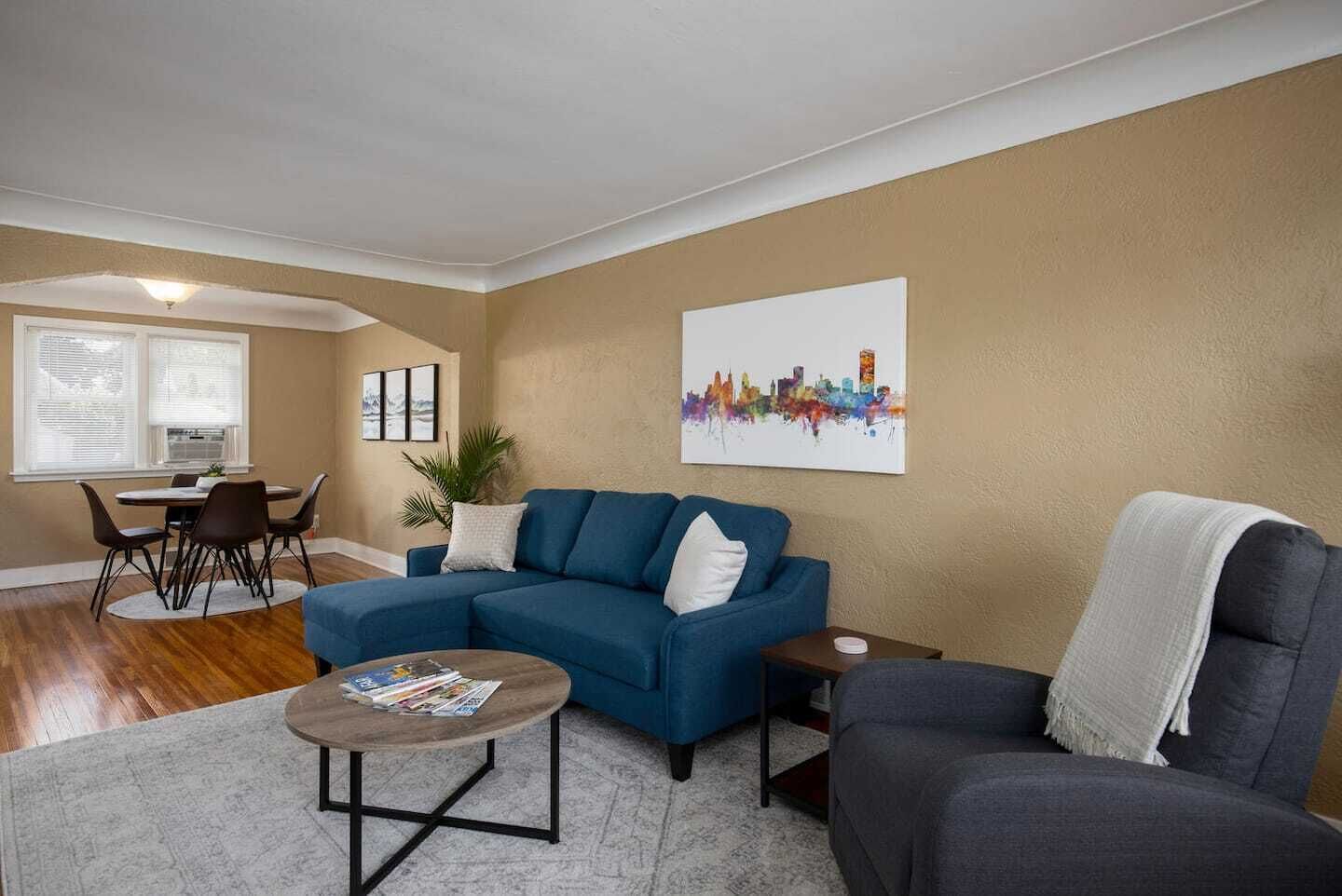 Open living space with plenty of natural light includes a sofa bed, recliner chair and dining room seating for 4.