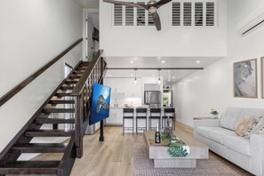 Ein modernes Interieur mit einer Treppe, einem Essbereich und einem Wohnzimmer.
