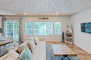 Una sala moderna con un sofá, una mesa de comedor y un televisor.