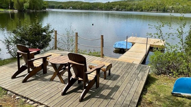 A wooden deck with a table and chairs overlooking a lake. - Diamond Lakehouse | SUP, Canoe, BBQ, Aurora Magic (Highland Grove)