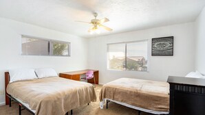A bedroom with two beds, a desk, a chair, a ceiling fan, and a window with blinds. - Classy 70-ies style home with Mineralized Spa (Desert Hot Springs)