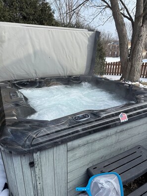 Un bain à remous avec un couvercle, un panneau de commande et un autocollant représentant le drapeau des États-Unis.