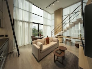 Una sala de estar moderna con sofá, mesa de centro y escalera.