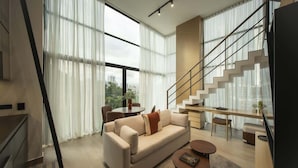 Una sala de estar moderna con sofá, mesa de centro y escalera.