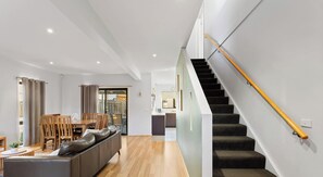 Ein modernes Interieur mit Treppe, Essbereich und Wohnzimmer.