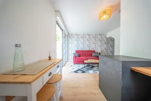 Eine moderne Küche mit einer Holzarbeitsplatte, einem roten Sofa und einem gemusterten Teppich.