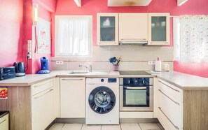Eine kleine Küche mit Waschmaschine, Backofen und Spüle.