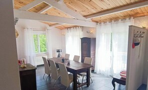 Ein Essbereich mit Holztisch, Stühlen, einem Schrank und einem Kühlschrank.