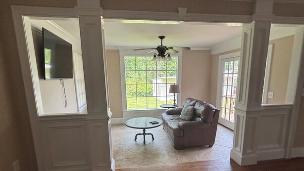 An open-plan living area with a wooden floor, a sofa, a small round table, and a ceiling fan. - Lux- Minimum 2 -Lexington With-Riverwalk & CAE (West Columbia)