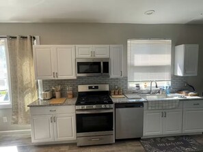 A kitchen with white cabinets, a microwave, stove, oven, and dishwasher. - 7 Minutes From DRAFT! (Pittsburgh)