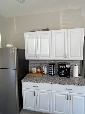 A kitchen with white cabinets, a stainless steel refrigerator, a coffee maker, and a paper towel holder. - 7 Minutes From DRAFT! (Pittsburgh)