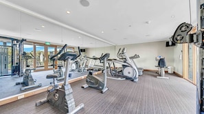 Et fitnesscenter med løbebånd, crosstrainere og styrkemaskiner.