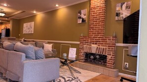 A living room with a brick fireplace, a sofa, and a glass coffee table.