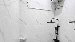 A bathroom with a shower, toilet, and a water heater mounted on the wall. - By The Padi - Homestay (Padang)