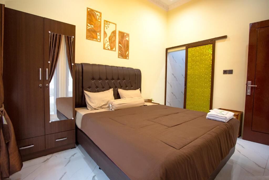A bedroom with a large bed, a wardrobe, and a mirror.