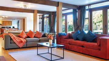 A spacious living area with a grey sofa, red sofa, and a coffee table.