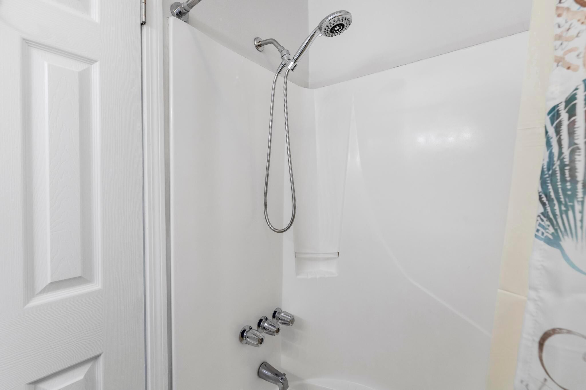 A shower with a handheld showerhead and a handheld hose.