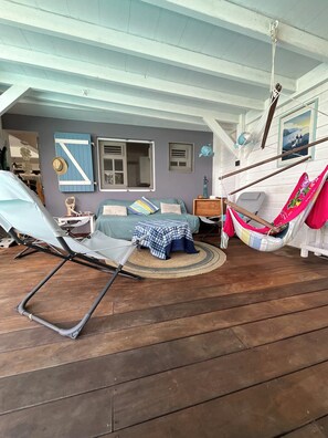 A room with a blue sofa, a hammock, a wooden floor, a window, and a wall-mounted shelf. - Villa Colibri - Private Pool - Panoramic View (Rivière-Salée)