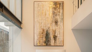 A modern interior with a large abstract painting, a marble bench, and a glass railing. - CONCORDIA CHAPULTEPEC (Guadalajara)