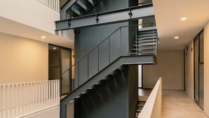 A multi-level interior with a central staircase, enclosed balconies, and a clean, modern design. - CONCORDIA CHAPULTEPEC (Guadalajara)