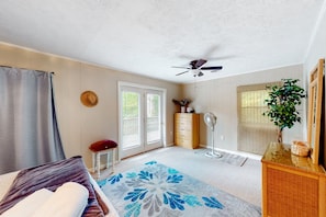 A bedroom with a bed, a ceiling fan, a dresser, a plant, and a window with blinds. - A Quiet Cove - Lakefront Home on Quiet Cove With Private Dock & Floater (Moneta)