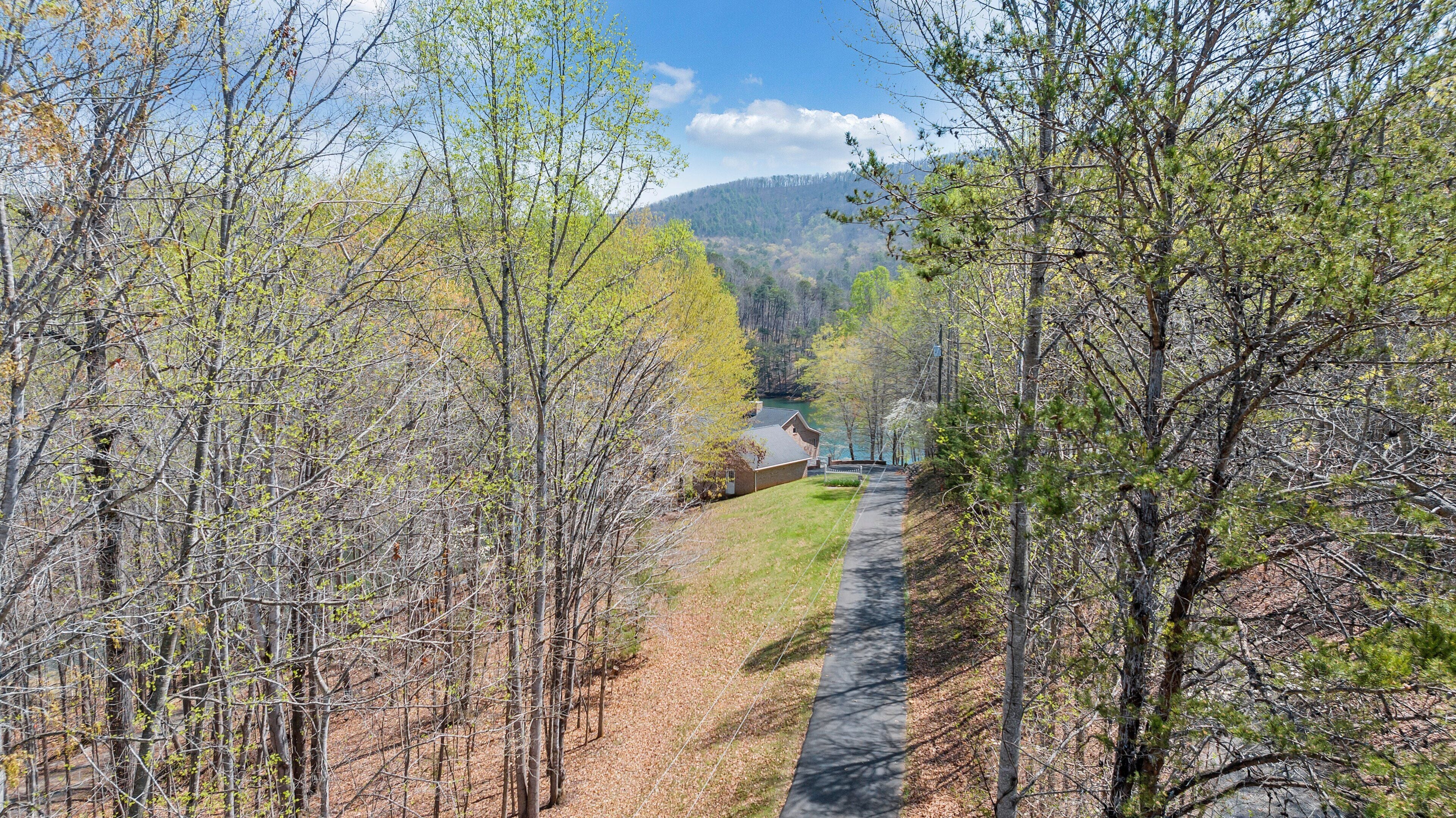 A pathway through a forested area with a building in the distance.