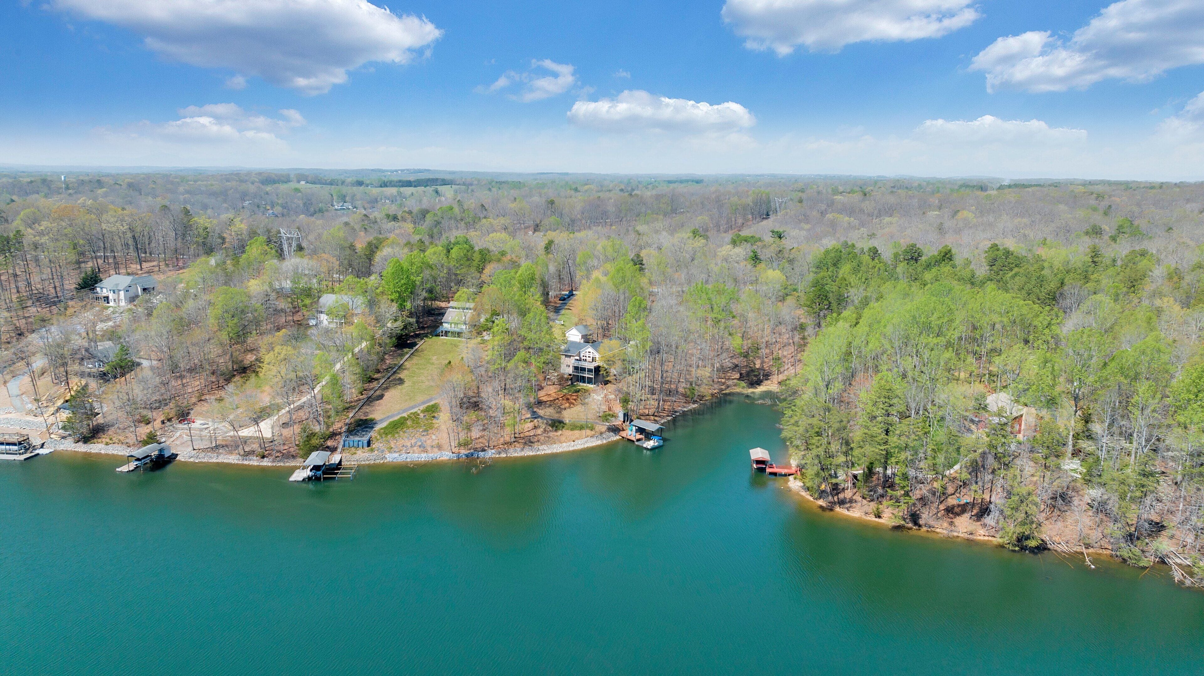 A river with boats, surrounded by trees and houses.