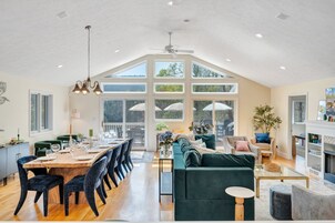 Amplia sala de estar con mesa de comedor, sillas, sofá y chimenea.