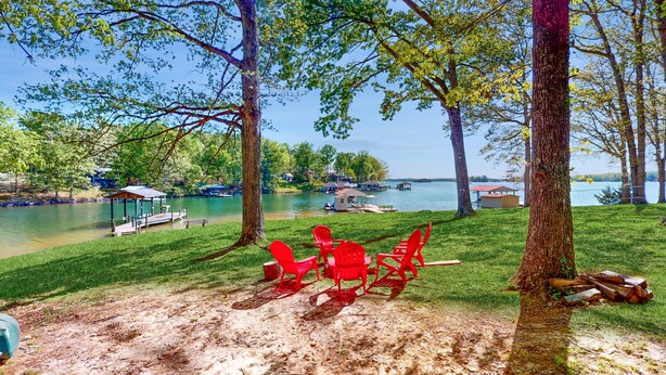 Un cadre idyllique au bord du lac, avec des chaises rouges, un kiosque et une jetée.