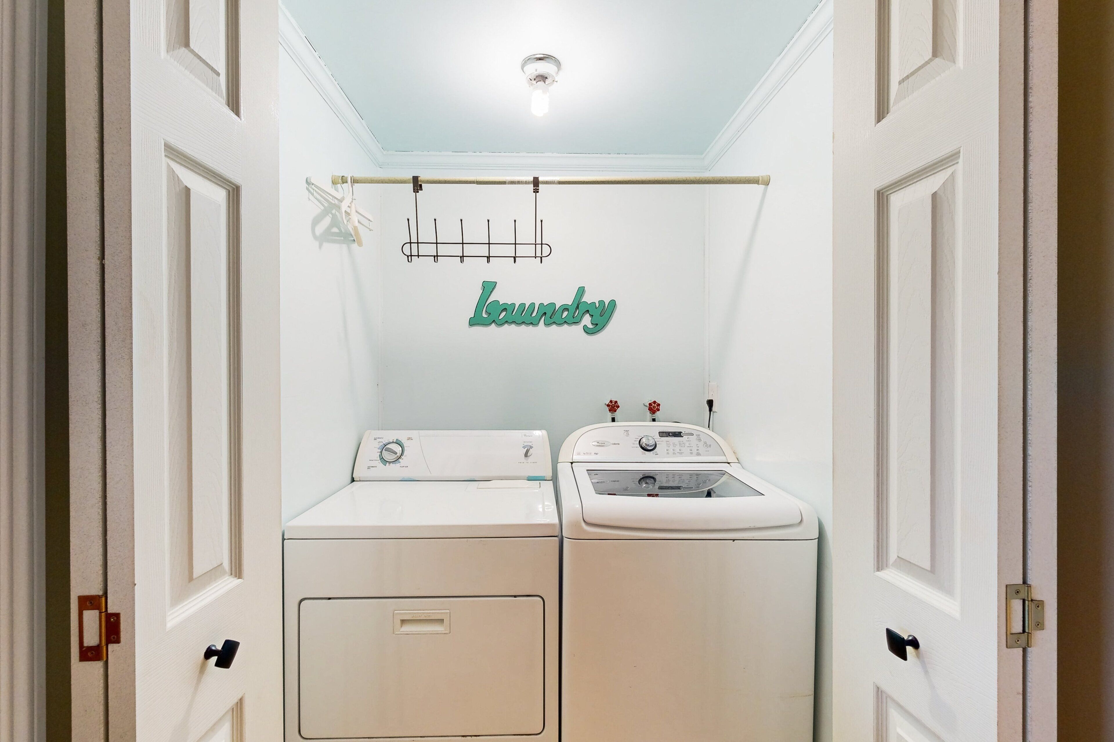A laundry room with two washing machines and a sink.