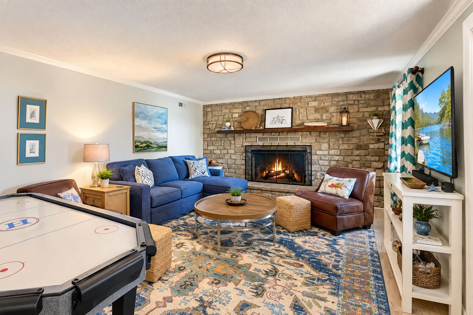 A cozy living room with a pool table, a blue sofa, a leather armchair, a fireplace, and a television.