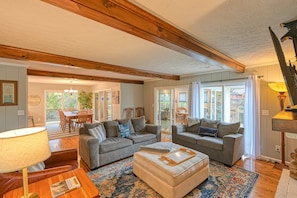 A spacious living room with two grey sofas, a coffee table, and a patterned rug. - Yellow Fellow - Lake House With hot Tub, Waterfront Deck, Swimming Cove & Firepit (Moneta)