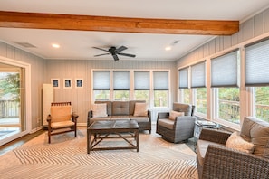 A sunroom with a ceiling fan, large windows with blinds, a sofa, chairs, and a coffee table. - Yellow Fellow - Lake House With hot Tub, Waterfront Deck, Swimming Cove & Firepit (Moneta)