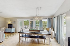 A dining area with a table, benches, and a chandelier. - Wet Feet Retreat - Beautiful Lake House With Incredible Views and Dock (Moneta)