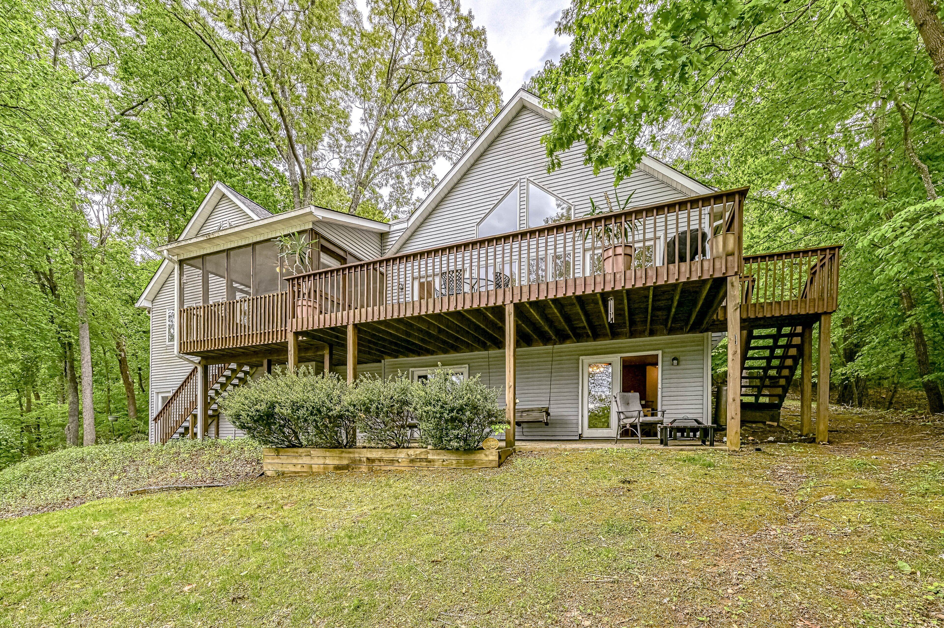 A two-story house with a covered porch and a small deck.