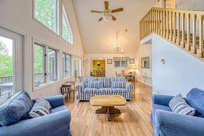 Ein geräumiges Wohnzimmer mit einer großen Couch, einem Holztisch und einer Treppe.