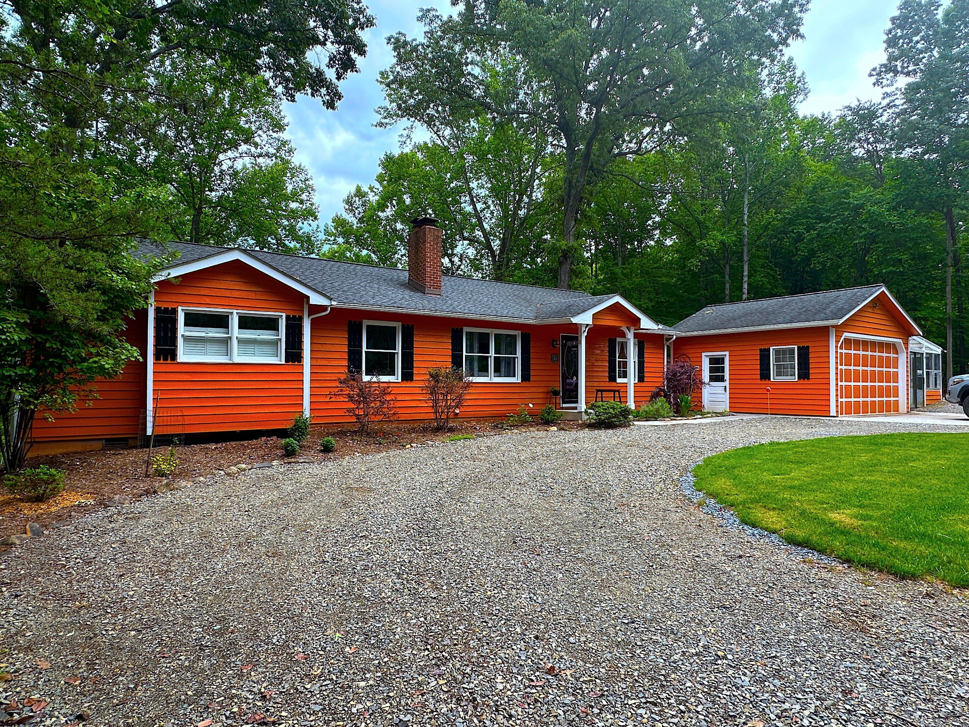 A two-story house with a gravel driveway and a garage.